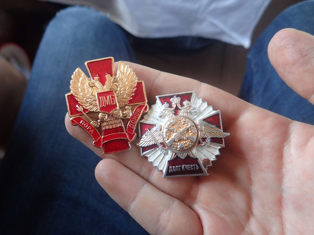 Military badges. He later gave the one on the right to me, using Google Translate to say 'souvenir' - I was humbled and surprised... I hope he can get another