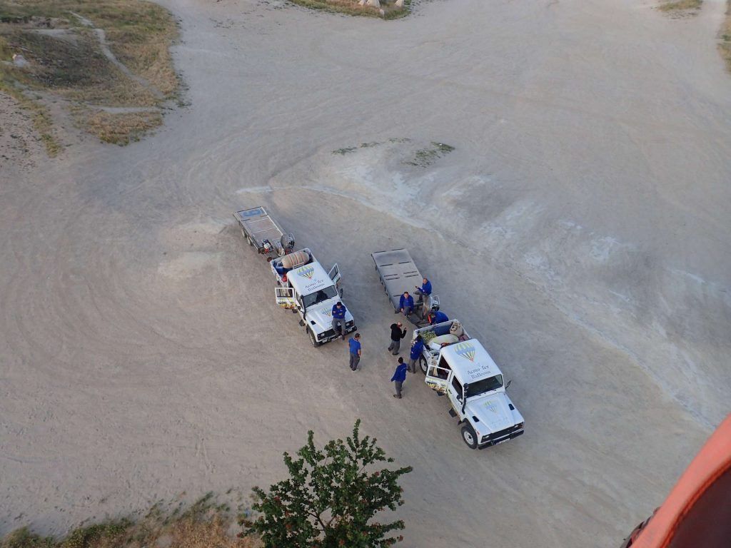 Below, the balloon collection teams idle and wave as they wait for them to drift towards their destinations