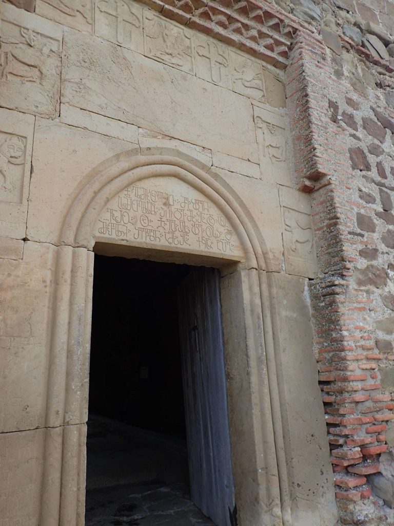 Stone church threshold. Georgian script is almost hilariously complex; it looks like Thai or Cambodian. Speaking it, too, requires lots of guttural through sounds and glottal-stops.