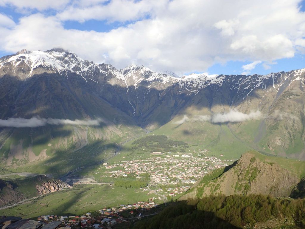 The impenetrable wall of the Caucasus with Stepantsminda clustered below it.