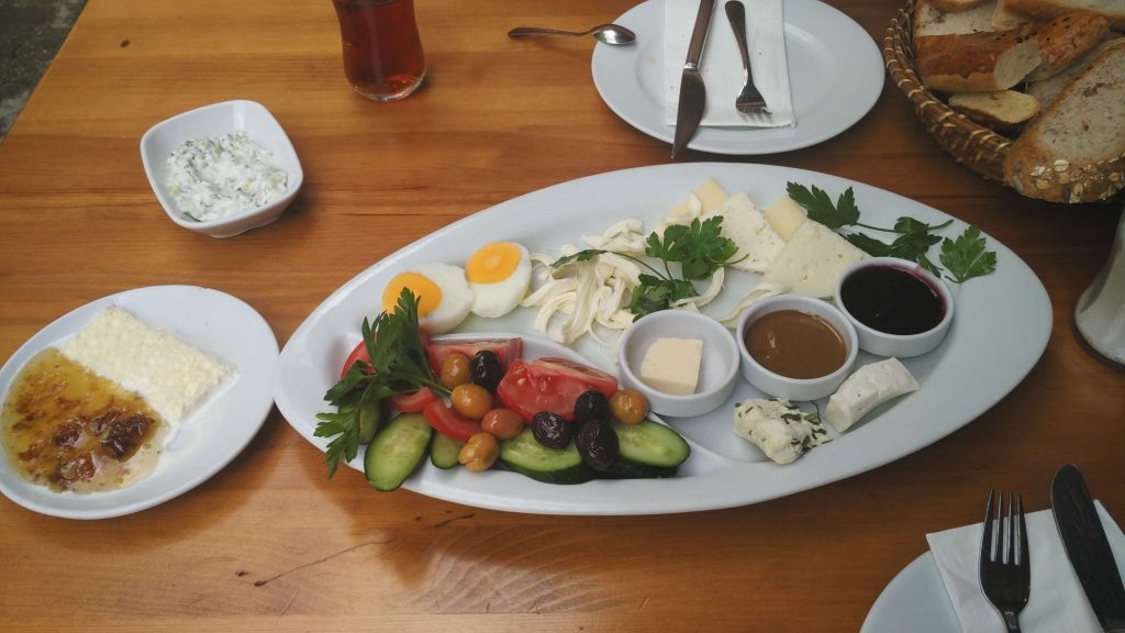 Turkish breakfast, featuring a variety of cheeses, olives, spreads, and the crowd favourite, bal kaymak on the left